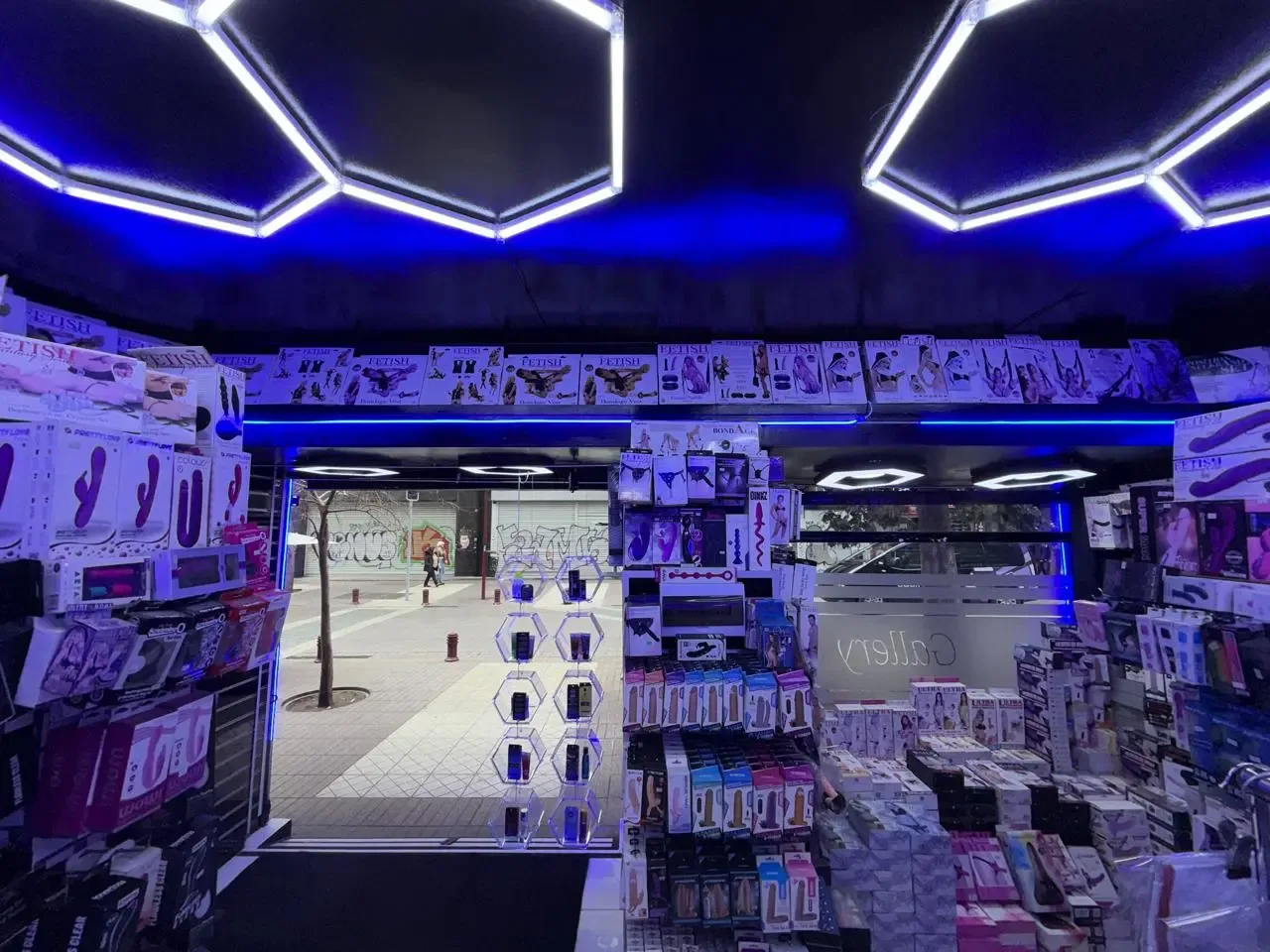 Interior de la tienda Boutique Gallery en Santiago Centro, con estanterías llenas de productos e iluminación hexagonal azul